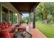Spacious covered patio with outdoor seating, lush lawn and mature palm trees at 7775 Still Lakes Dr, Odessa, FL 33556