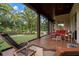 Expansive covered patio with pond view, plush outdoor seating and manicured lawn at 7775 Still Lakes Dr, Odessa, FL 33556