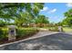 Paver and asphalt driveway leads to estate home, framed by stone pillars and mature landscaping at 7775 Still Lakes Dr, Odessa, FL 33556