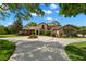Stately home with circular driveway, lush landscaping, and elegant architectural details at 7775 Still Lakes Dr, Odessa, FL 33556
