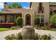Close-up of front entrance with manicured landscaping, fountain, and arched doorway, enhancing curb appeal at 7775 Still Lakes Dr, Odessa, FL 33556