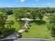 A beautiful landscaped circular driveway leads up to an elegant home nestled among mature trees on a lush green lawn at 7775 Still Lakes Dr, Odessa, FL 33556