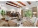 Stylish living room with beamed ceiling, neutral furniture, and backyard views, offering a comfortable space at 7775 Still Lakes Dr, Odessa, FL 33556