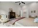 Comfortable main bedroom featuring a large television, armchairs, ceiling fan, and sitting area at 7775 Still Lakes Dr, Odessa, FL 33556