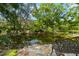 Picturesque pond with stone accents, mature trees, and lush vegetation at 7775 Still Lakes Dr, Odessa, FL 33556
