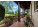 Inviting porch with tile flooring, dark wood beams, and view of the landscaped lawn at 7775 Still Lakes Dr, Odessa, FL 33556