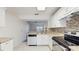 Bright kitchen featuring white cabinets, speckled granite countertops, and stainless steel appliances at 7802 Hardwick Dr # 1126, New Port Richey, FL 34653