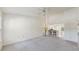 Spacious open-concept living room with neutral carpet, ceiling fan, and view into kitchen at 7802 Hardwick Dr # 1126, New Port Richey, FL 34653
