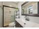 Bathroom featuring a glass shower with marble tile, a sleek vanity, and a large framed mirror at 8408 Flagstone Dr, Tampa, FL 33615