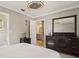 Bedroom showcasing a ceiling fan, large dresser, and view of a bathroom with natural light at 8408 Flagstone Dr, Tampa, FL 33615