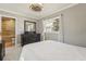 Bedroom showcasing a ceiling fan, large dresser, and view of a bathroom with natural light at 8408 Flagstone Dr, Tampa, FL 33615