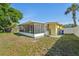 Exterior view of the home showing the enclosed lanai and the backyard at 8408 Flagstone Dr, Tampa, FL 33615