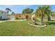 Charming yellow home featuring a well-maintained lawn and mature palm trees, creating inviting curb appeal at 8408 Flagstone Dr, Tampa, FL 33615
