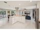 Open floor plan featuring kitchen island, stainless appliances, and seamless flow to the outdoor living space at 8408 Flagstone Dr, Tampa, FL 33615