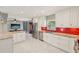 Open kitchen design featuring white cabinets, stainless steel appliances, granite counters, and a colorful red backsplash at 8408 Flagstone Dr, Tampa, FL 33615