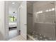 Modern bathroom with glass shower enclosure, gray tile, and view into the bedroom at 907 Arlington N Ave, St Petersburg, FL 33705