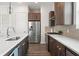 Kitchen featuring quartz countertops, stainless steel appliances, tile backsplash, and dark wood cabinets at 907 Arlington N Ave, St Petersburg, FL 33705