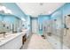 Bright bathroom featuring dual sinks, a spacious glass shower, and stylish blue walls at 10505 Inglenook Ter, Palmetto, FL 34221
