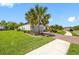 Lovely home with brick driveway, lush landscaping, and mature palm trees at 10505 Inglenook Ter, Palmetto, FL 34221