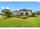 Beautiful single-story home featuring a well-manicured lawn with tropical landscaping and a clay tile roof at 10505 Inglenook Ter, Palmetto, FL 34221