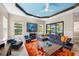Comfortable living room with tray ceiling, modern furniture, and sliding door access to the pool at 10505 Inglenook Ter, Palmetto, FL 34221