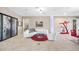 Bright living room with curved white couch, red rug, tile floors, and modern art at 10505 Inglenook Ter, Palmetto, FL 34221