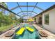 Screened-in pool area featuring a pool, spa, and outdoor kitchen with grill at 10505 Inglenook Ter, Palmetto, FL 34221