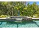 Inviting in-ground pool features a tiled hot tub with a decorative water feature and lush tropical landscaping at 10505 Inglenook Ter, Palmetto, FL 34221