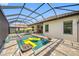 An inviting screened-in pool area with spa and outdoor kitchen under a blue sky at 10505 Inglenook Ter, Palmetto, FL 34221