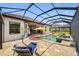 Screened-in patio features a pool, hot tub, lounge chair, yellow umbrella, and access to the home's interior at 10505 Inglenook Ter, Palmetto, FL 34221