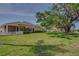 Well-maintained backyard with lush lawn and a partial view of the screened-in patio at 1129 Haley Ln, Dunedin, FL 34698