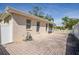 Expansive backyard paver area, enclosed by a white fence, provides a private outdoor space at 1129 Haley Ln, Dunedin, FL 34698