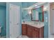 Bright bathroom with a cherry wood vanity, soft lighting, and a door to the toilet and shower area at 1129 Haley Ln, Dunedin, FL 34698