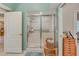 Bathroom featuring an accessible shower stall with sliding glass doors and a wooden storage seat at 1129 Haley Ln, Dunedin, FL 34698
