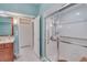 Modern bathroom with a glass-enclosed shower featuring safety bars, and a cherry wood vanity with marble countertop at 1129 Haley Ln, Dunedin, FL 34698