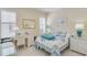 Cozy bedroom with a queen-sized bed, white wicker furniture, and ample natural light from the window at 1129 Haley Ln, Dunedin, FL 34698