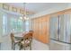 Eat-in kitchen with stainless steel fridge, light-colored cabinetry, and natural light from large bay windows at 1129 Haley Ln, Dunedin, FL 34698
