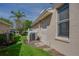 Exterior view of a home with a well-kept side yard, AC unit, and neutral paint at 1129 Haley Ln, Dunedin, FL 34698