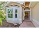 Close-up of the front entrance featuring a decorative glass door and sidelight windows at 1129 Haley Ln, Dunedin, FL 34698
