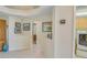 Hallway features tile flooring, neutral walls adorned with art, and leads to the laundry room at 1129 Haley Ln, Dunedin, FL 34698