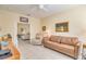 Comfortable living room offering a leather sofa, a recliner chair, and neutral tile flooring, perfect for relaxation at 1129 Haley Ln, Dunedin, FL 34698
