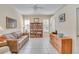 Inviting living room showcasing a leather sofa, a filled bookshelf, and neutral tile flooring throughout at 1129 Haley Ln, Dunedin, FL 34698