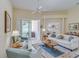 Inviting living room showcasing neutral decor, tiled flooring, and sliding glass doors to the patio at 1129 Haley Ln, Dunedin, FL 34698