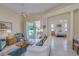Comfortable living room with tile floors that opens to a patio and connects to the main bedroom at 1129 Haley Ln, Dunedin, FL 34698