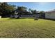 Large, well-maintained backyard featuring a screened patio, fire pit, and ample green space at 11708 Nicklaus Cir, Tampa, FL 33624
