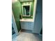 Bathroom vanity with white cabinet, mirror, and beige tile flooring at 11708 Nicklaus Cir, Tampa, FL 33624
