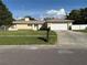 Charming single-story home with a well-manicured lawn and attached two-car garage at 11708 Nicklaus Cir, Tampa, FL 33624