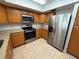 Modern kitchen with stainless steel appliances, wooden cabinets, and tiled floors at 11708 Nicklaus Cir, Tampa, FL 33624