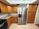 Kitchen featuring stainless steel refrigerator, wooden cabinets, and tiled floors at 11708 Nicklaus Cir, Tampa, FL 33624
