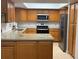 Well-lit kitchen with wooden cabinets, stainless steel appliances, and modern countertops at 11708 Nicklaus Cir, Tampa, FL 33624
